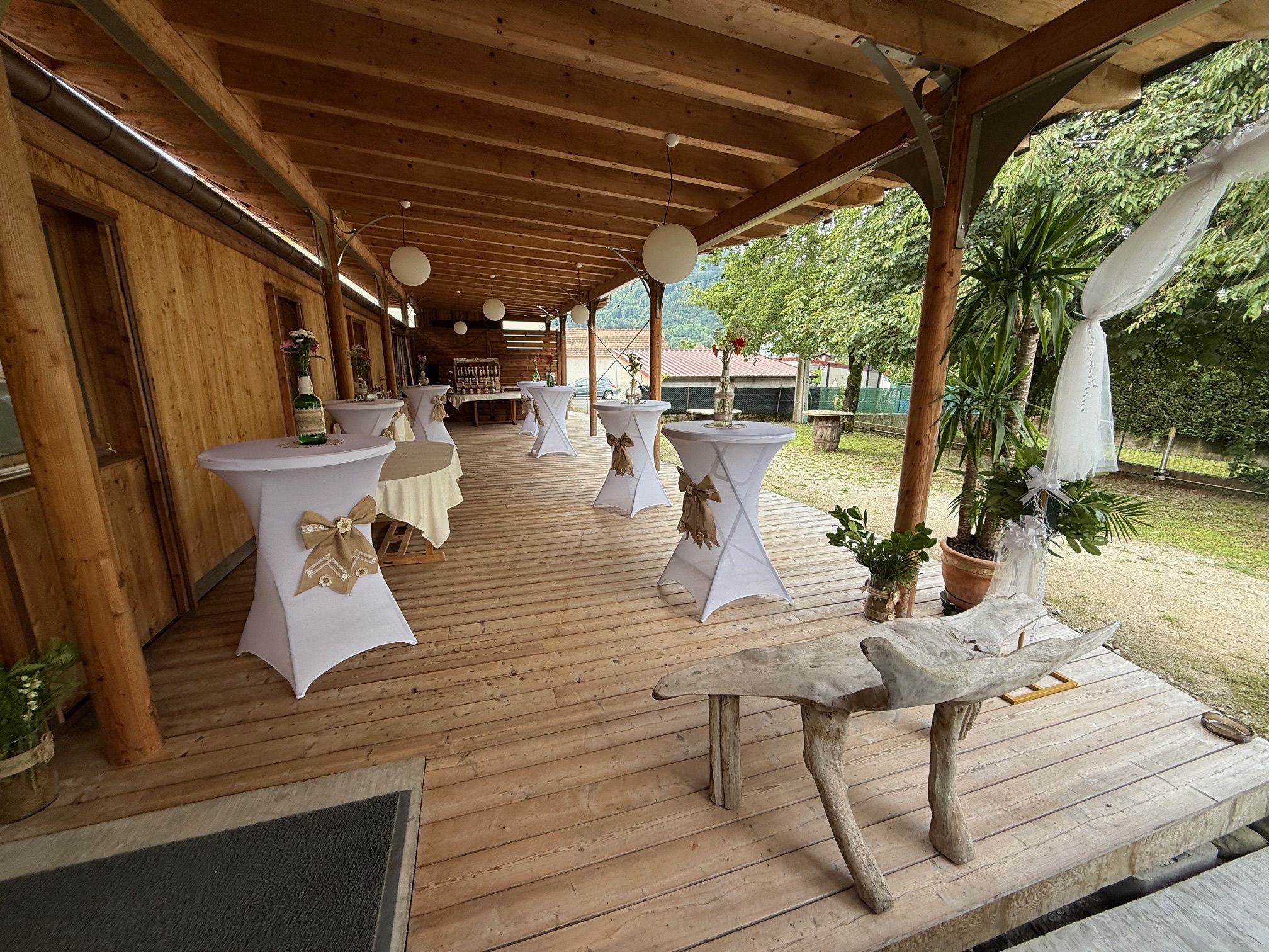 La terrasse dressée pour un cocktail de mariage, mange-debout habillés de lin
